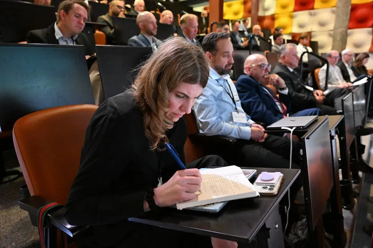 Attendees listening and taking notes during an executive event